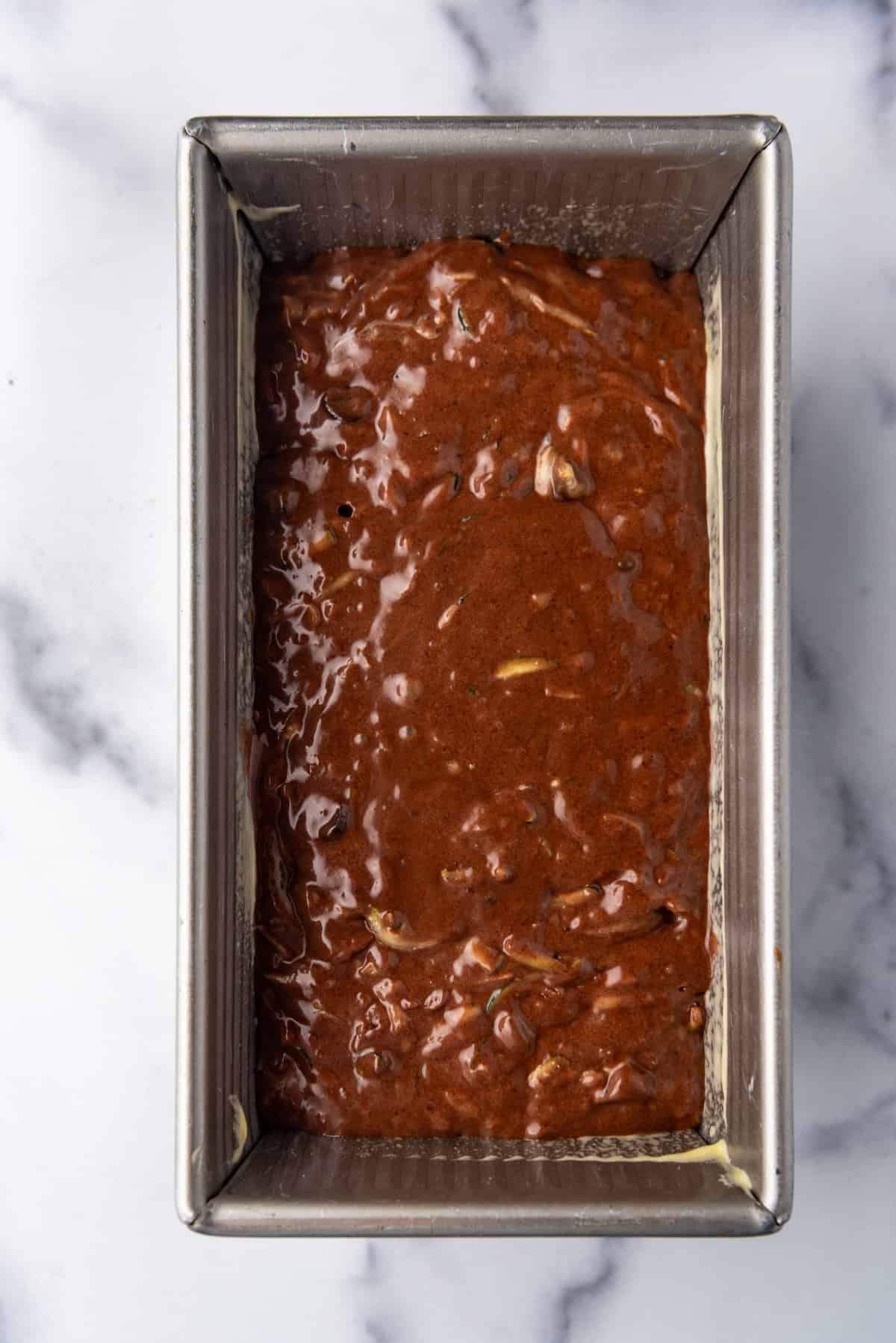 Top view of zucchini bread batter in a loaf pan.