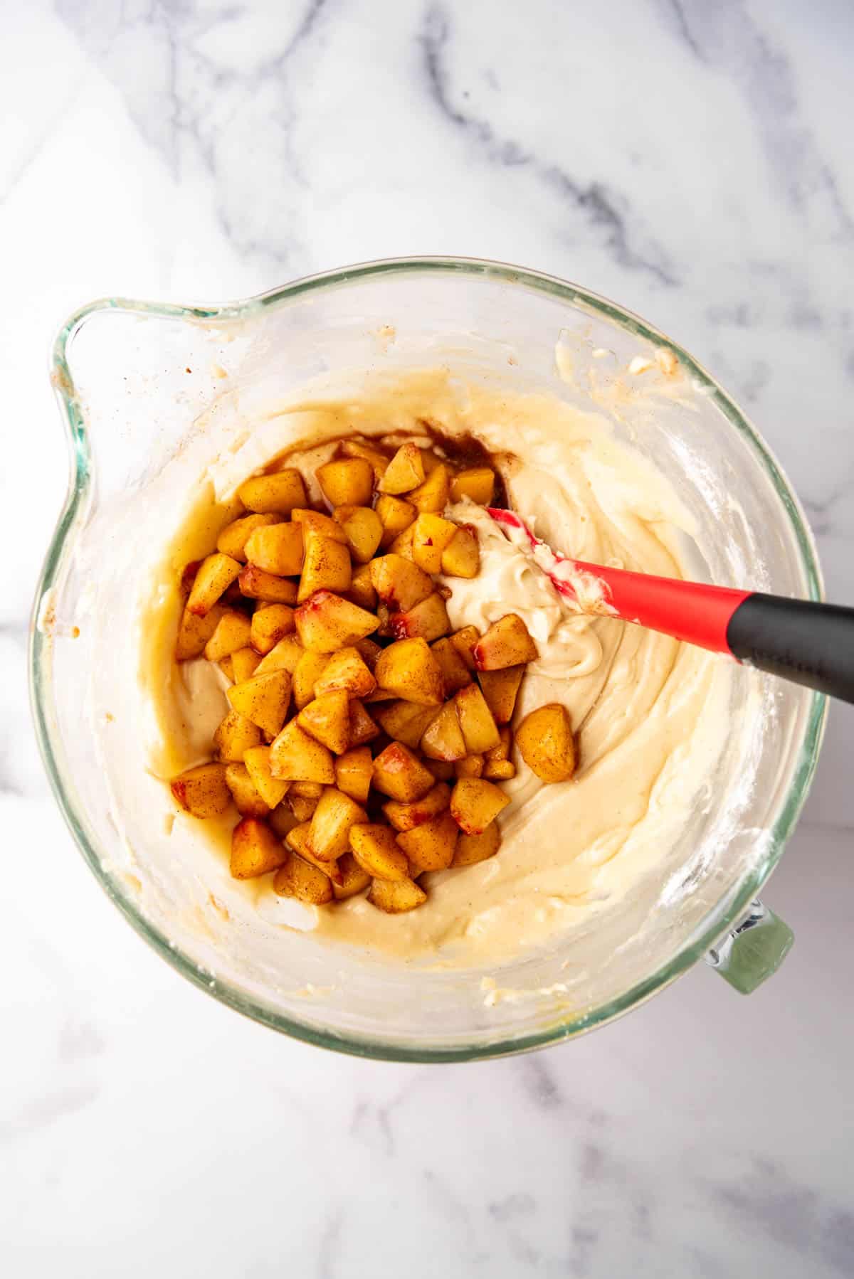 Adding chopped peaches to pie filling.