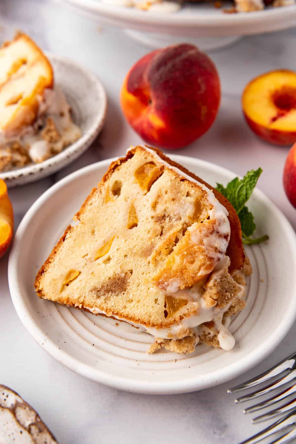 A slice of peach cobbler pound cake on a white plate.