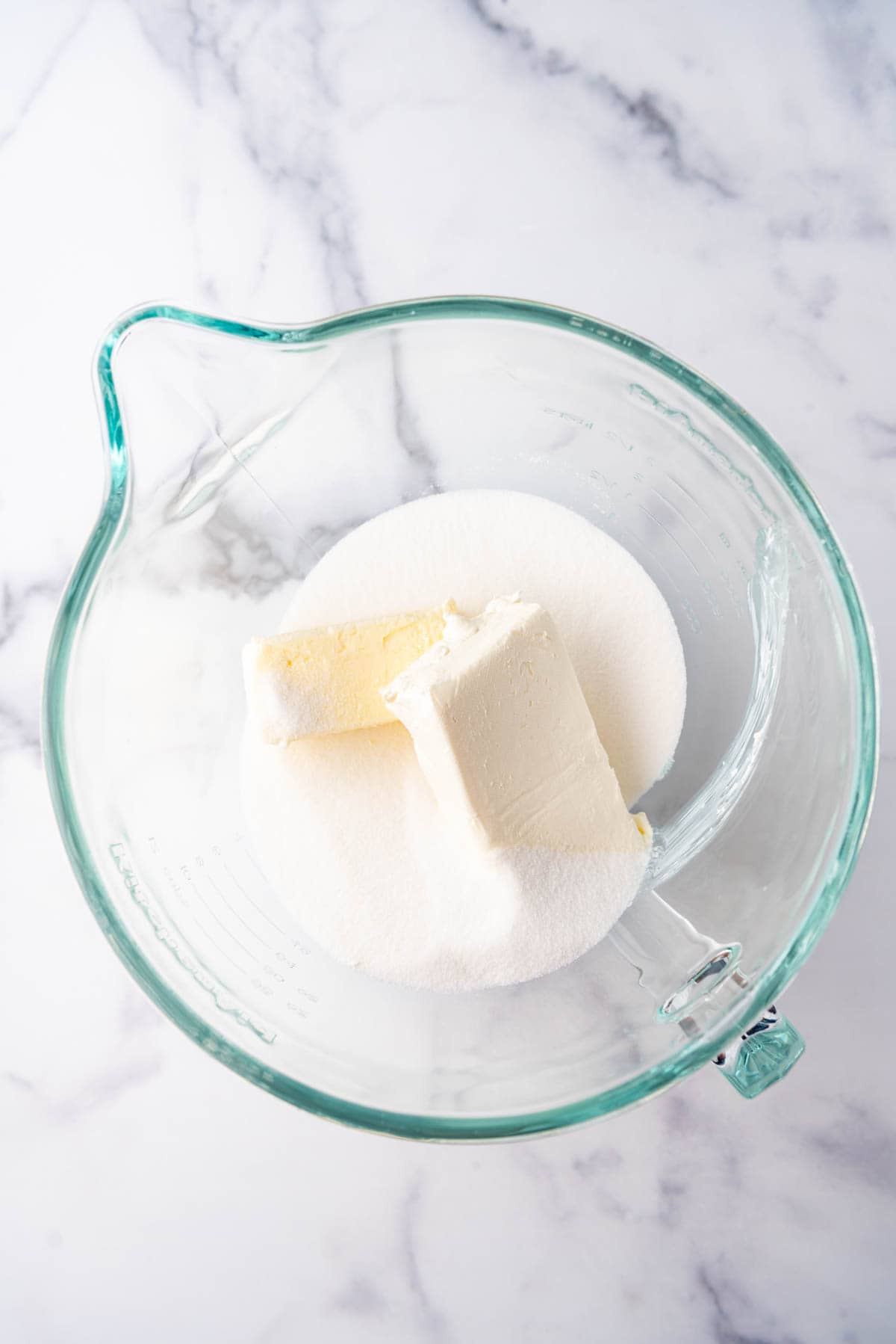 Combining butter, cream cheese, and sugar in a large mixing bowl.