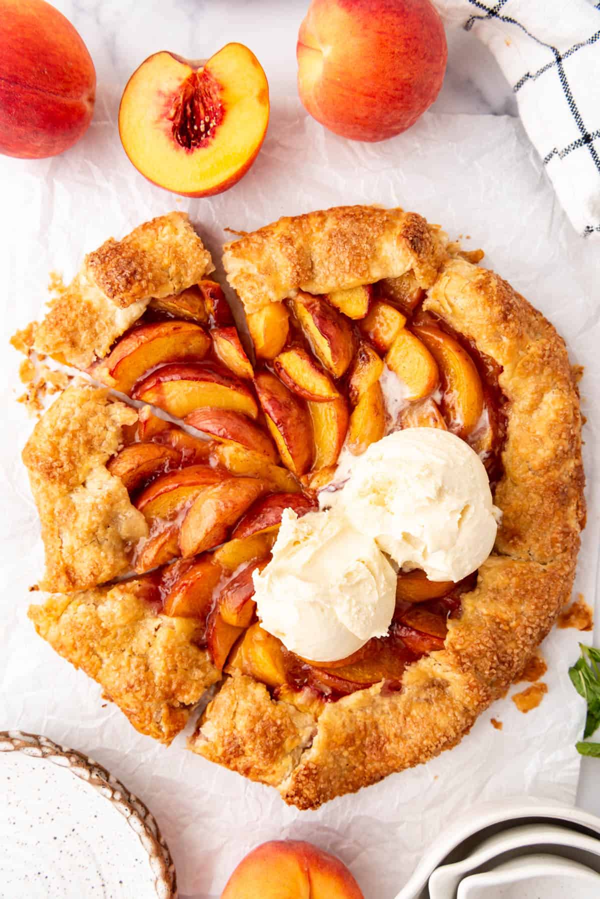 A baked peach galette with scoops of ice cream on top.