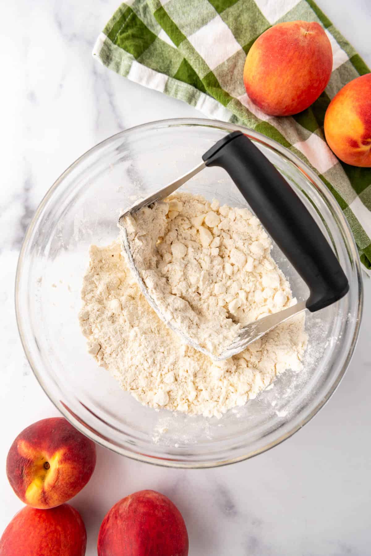 Using a pastry cutter to cut butter into flour for a galette crust.