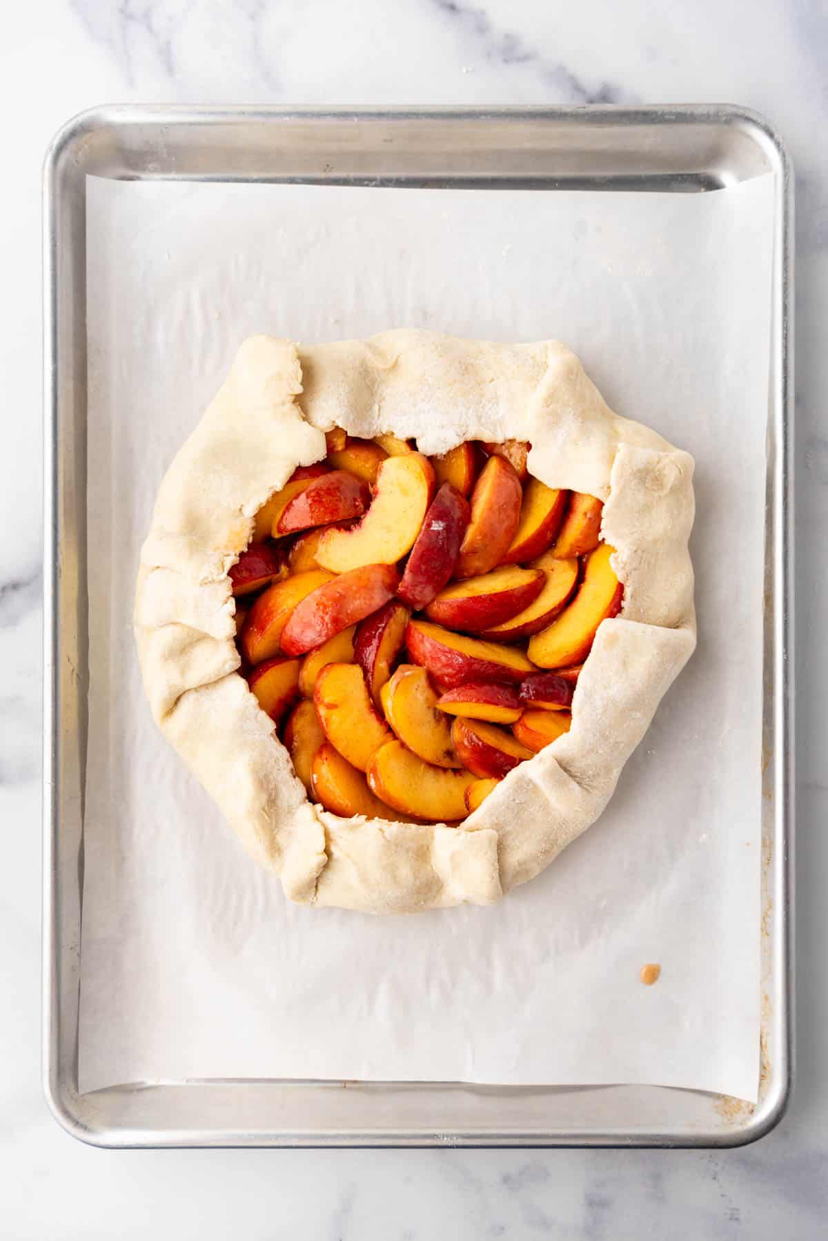 A pastry crust with the edges folded over peach filling in the middle to create a galette.