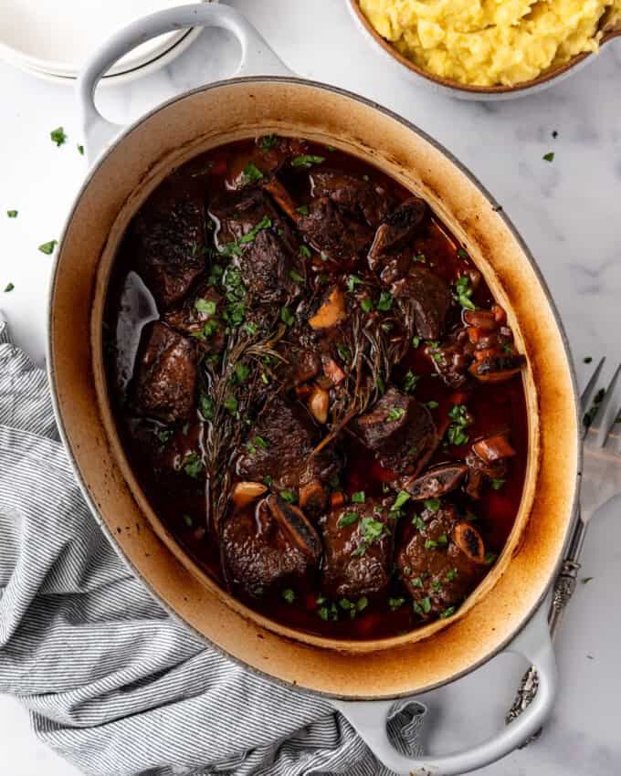 Overhead image of large dutch oven containing cooked Braised Short Ribs meal.