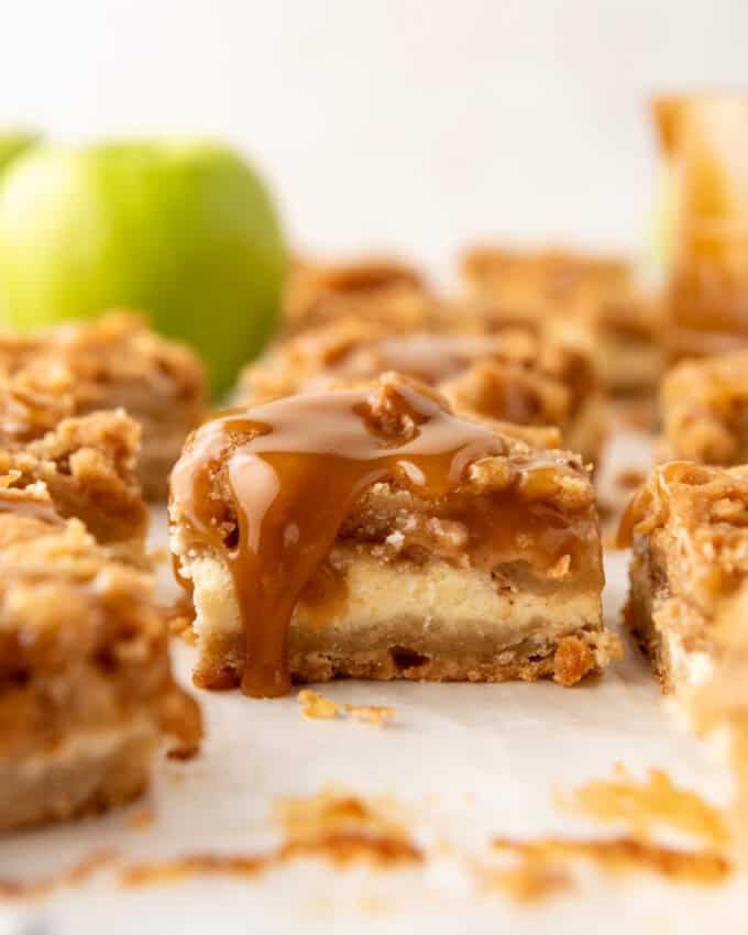 An image of a caramel apple cheesecake bar with caramel dripping down the side.