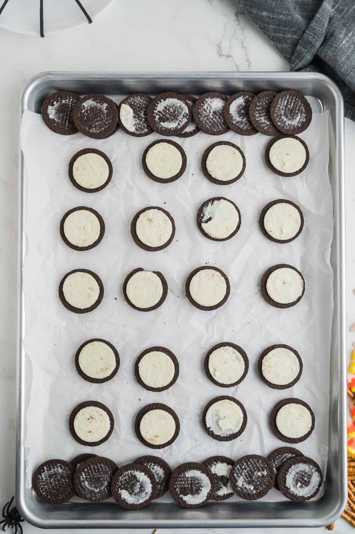 Oreos that have had their tops twisted off on a baking sheet.