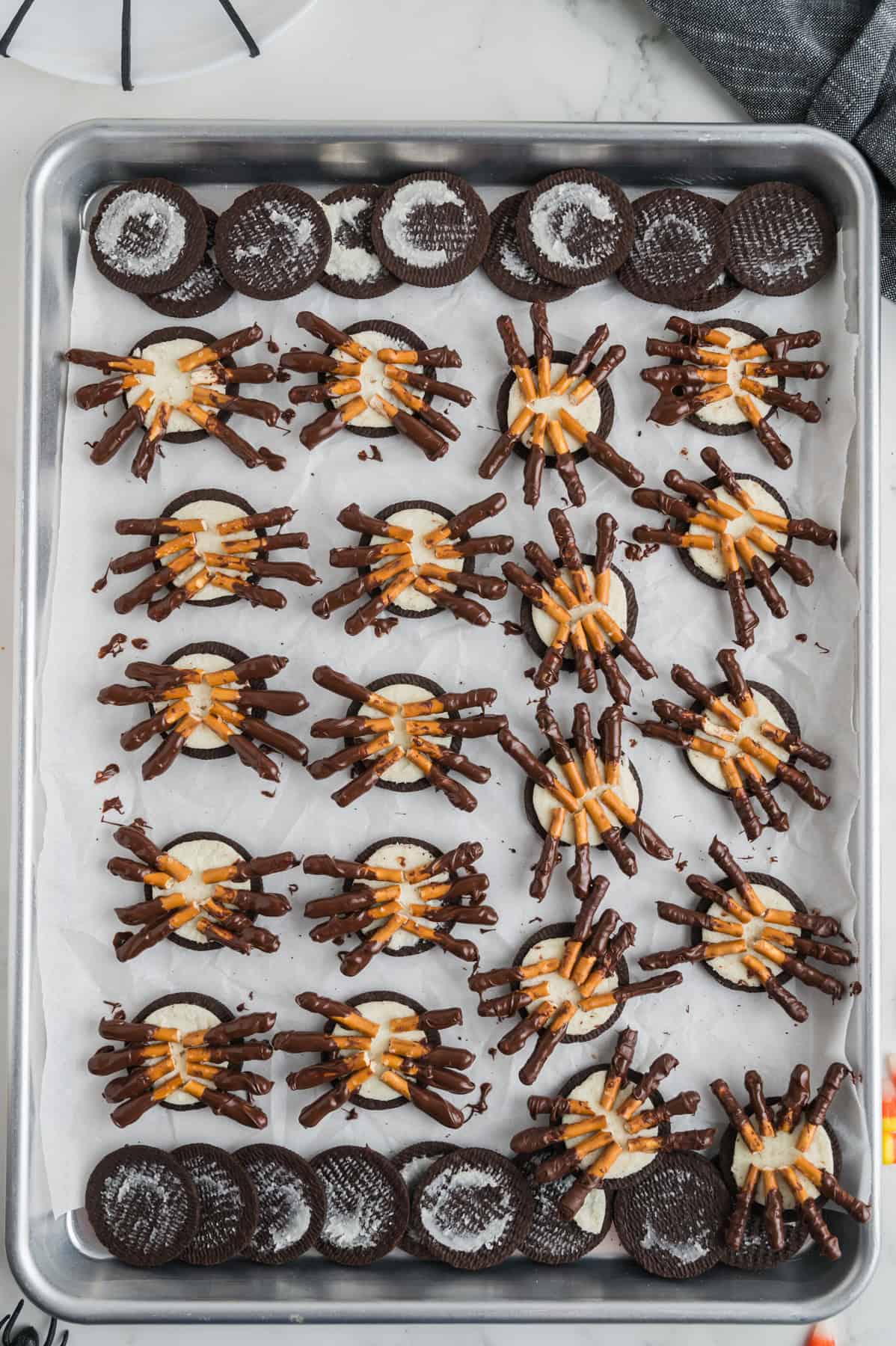 Oreo halves with chocolate covered pretzels pressed onto them to look like spider legs.