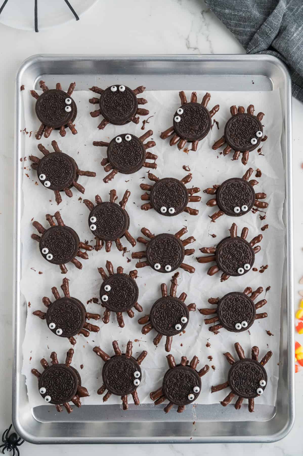 Assembled Oreo spiders on a baking sheet.