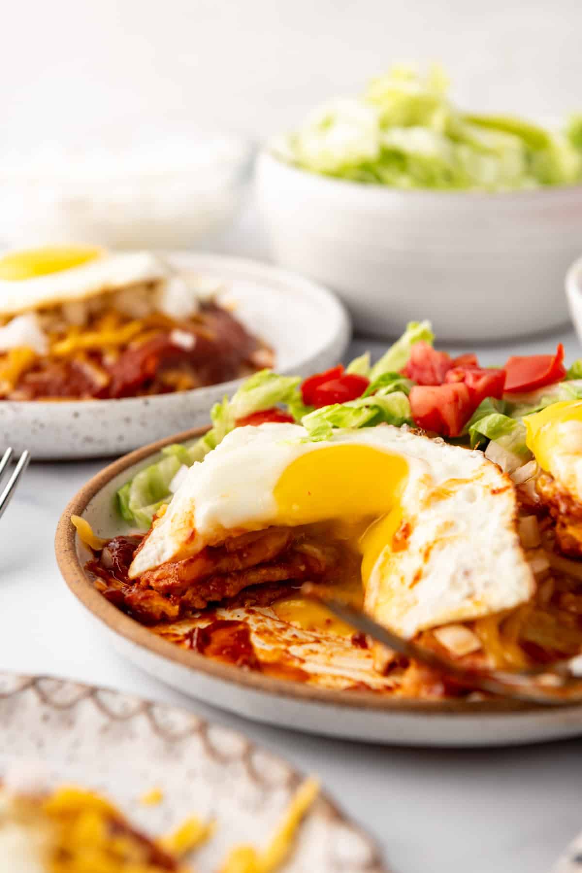 An image of stacked enchiladas with a bite taken out of them.