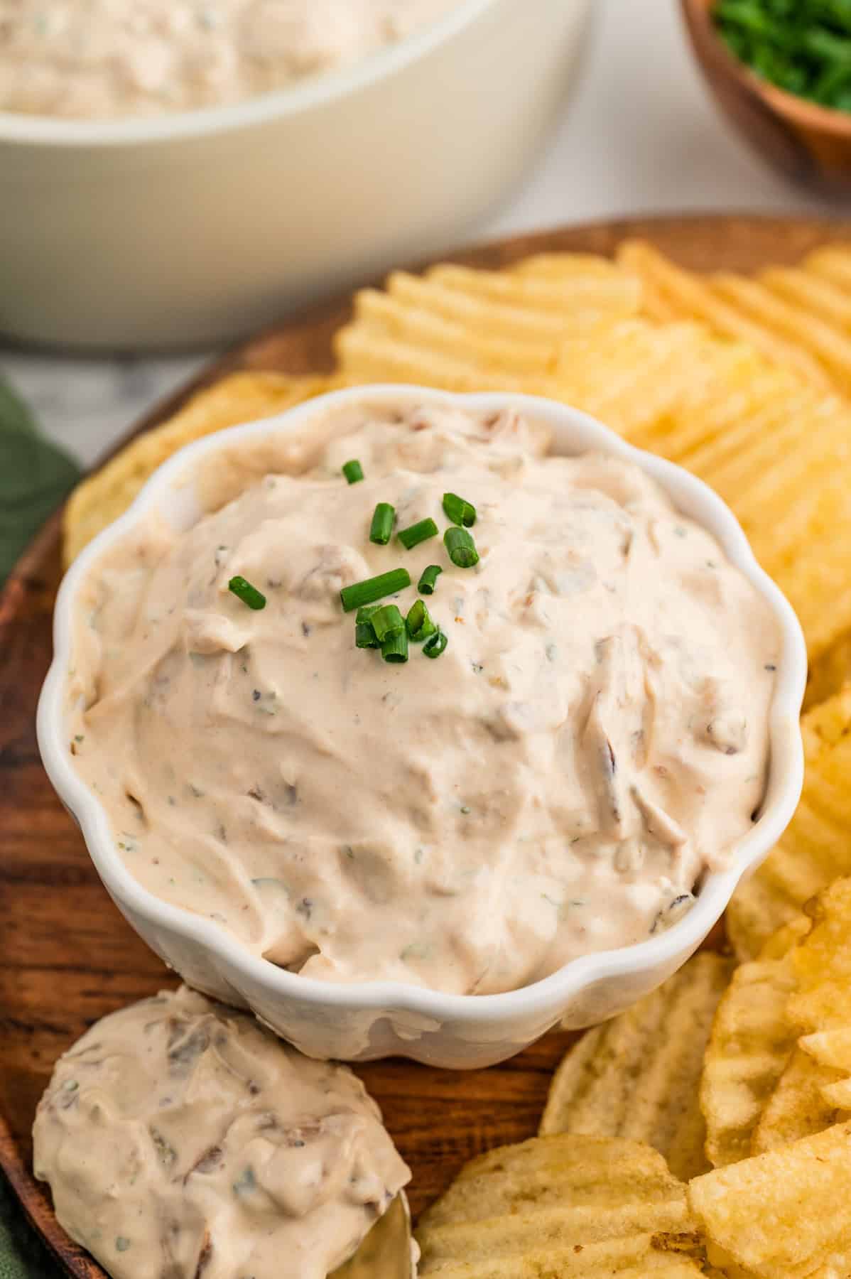 A bowl of french onion dip decorated with chopped chives on top.