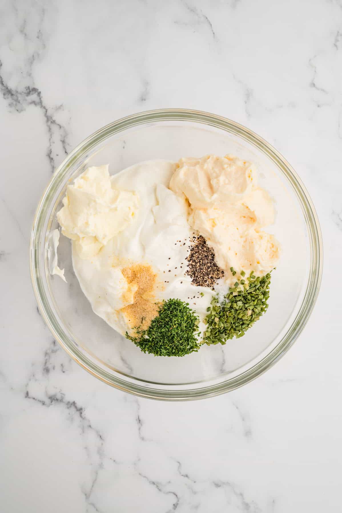 Combining dip ingredients in a glass bowl.