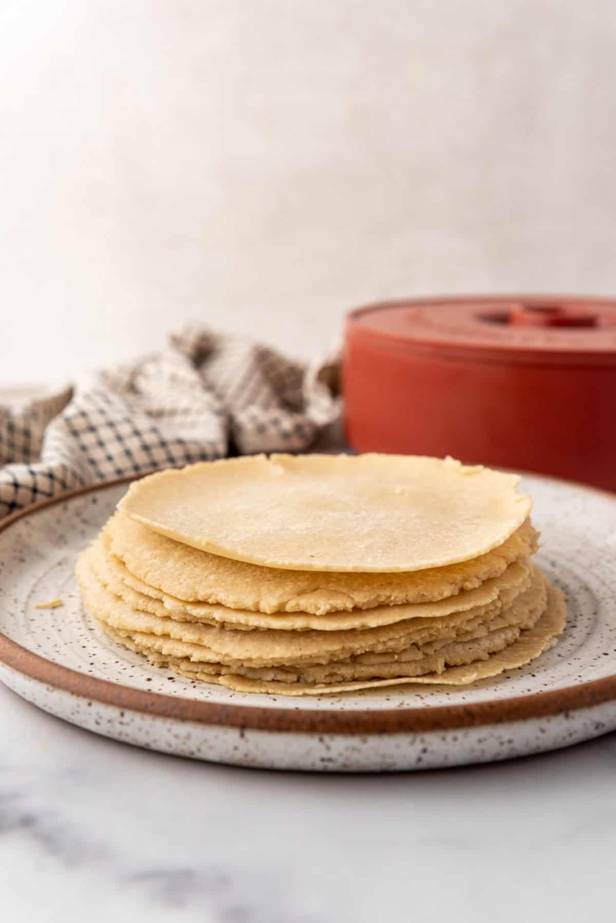 Une pile de tortillas de maïs maison avec texte superposé.