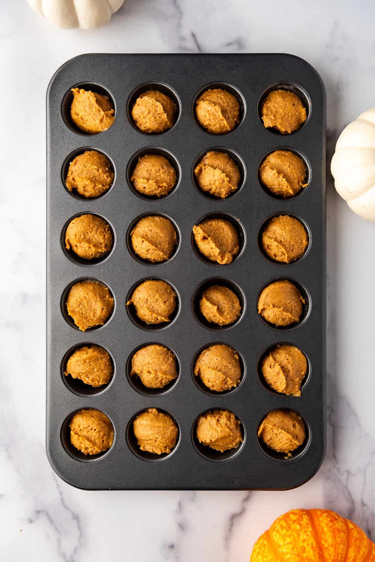 Mini pumpkin muffins in a mini pumpkin muffin pan.