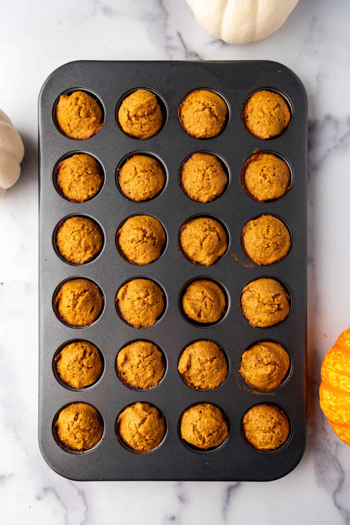 Baked pumpkin muffins in a mini muffin pan.