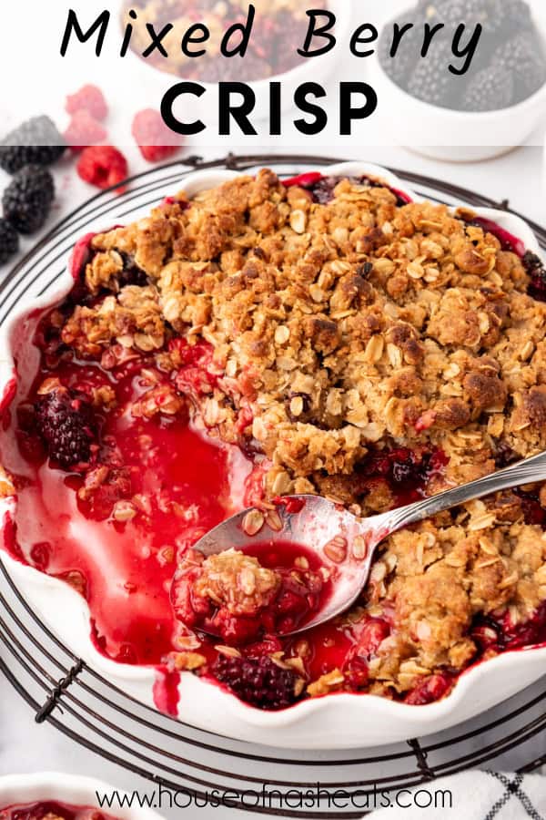 A mixed berry crisp with scoops removed from the pan with text overlay.