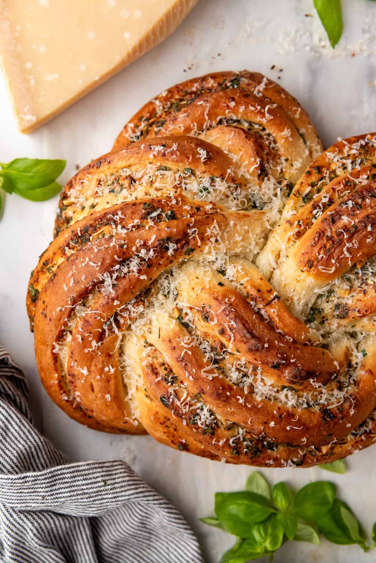 A close image of a golden brown loaf of swirled garlic herb bread.