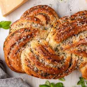 A close image of a golden brown loaf of swirled garlic herb bread.