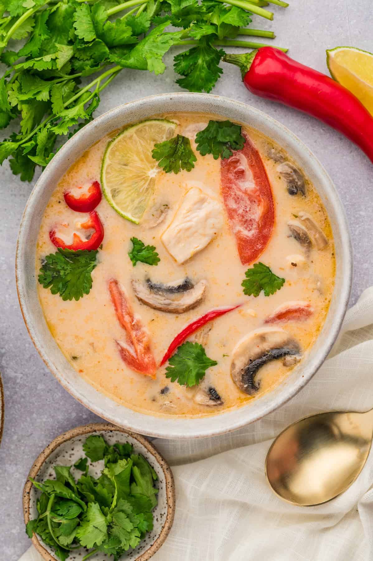 An overhead image of a bowl of tom kha gai soup.