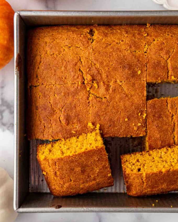 An overhead image of pieces of sliced pumpkin cornbread in a baking pan.