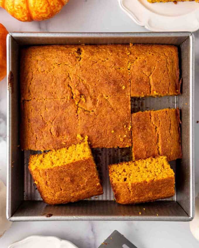 A pan of moist pumpkin cornbread that has been cut into squares.