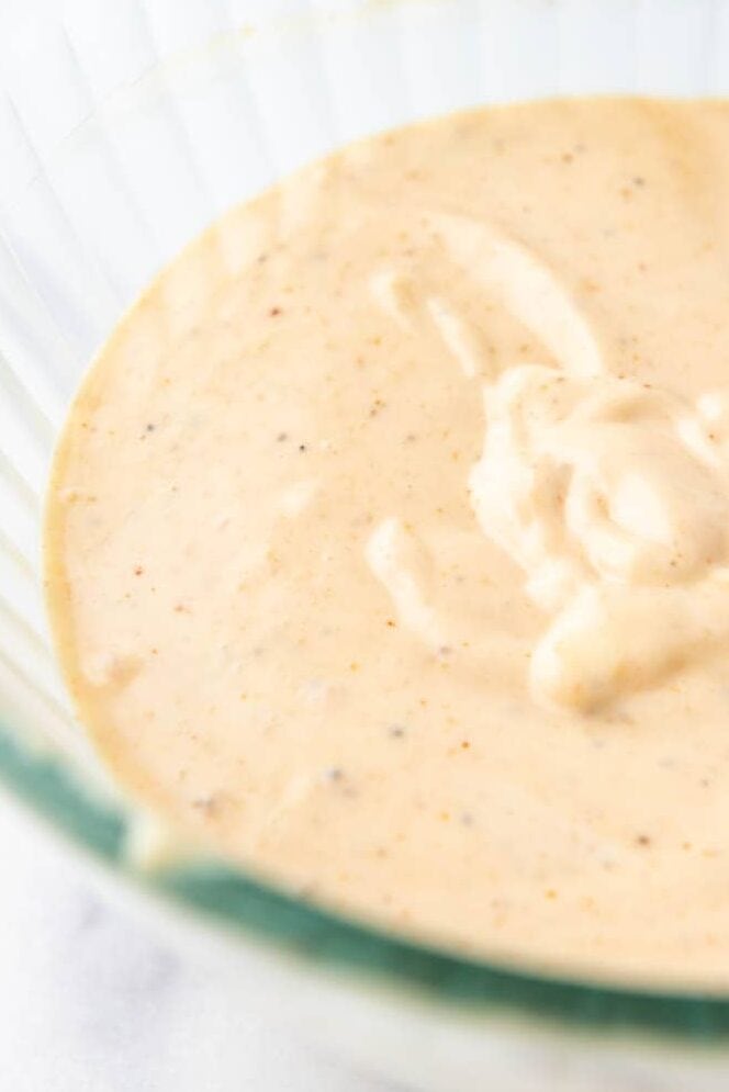 A batch of homemade yum yum sauce in a glass mixing bowl.