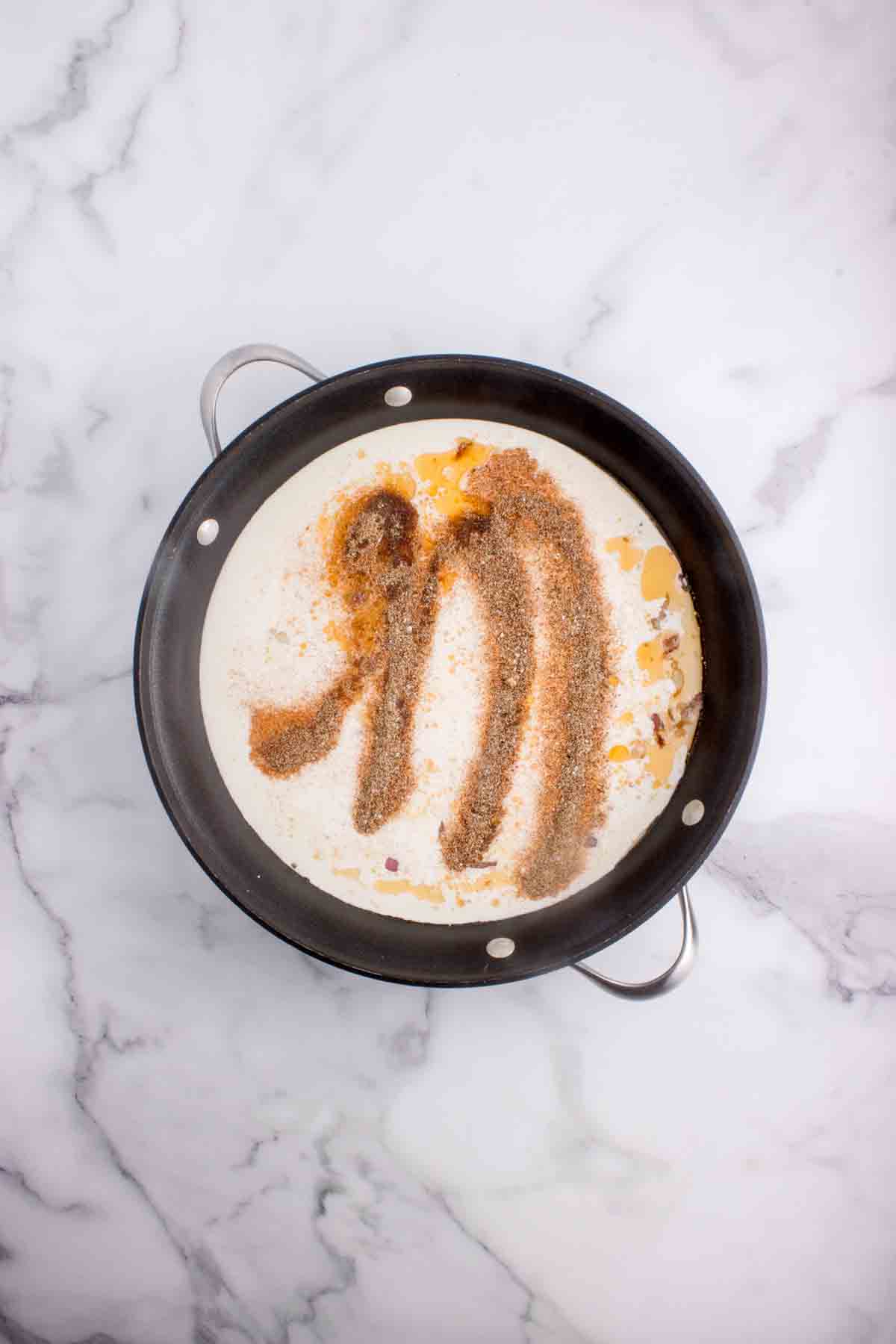 Adding spices to a pan.