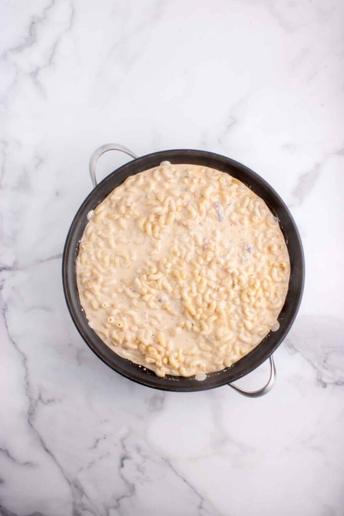 Cooked macaroni noodles stirred into a cheese sauce.