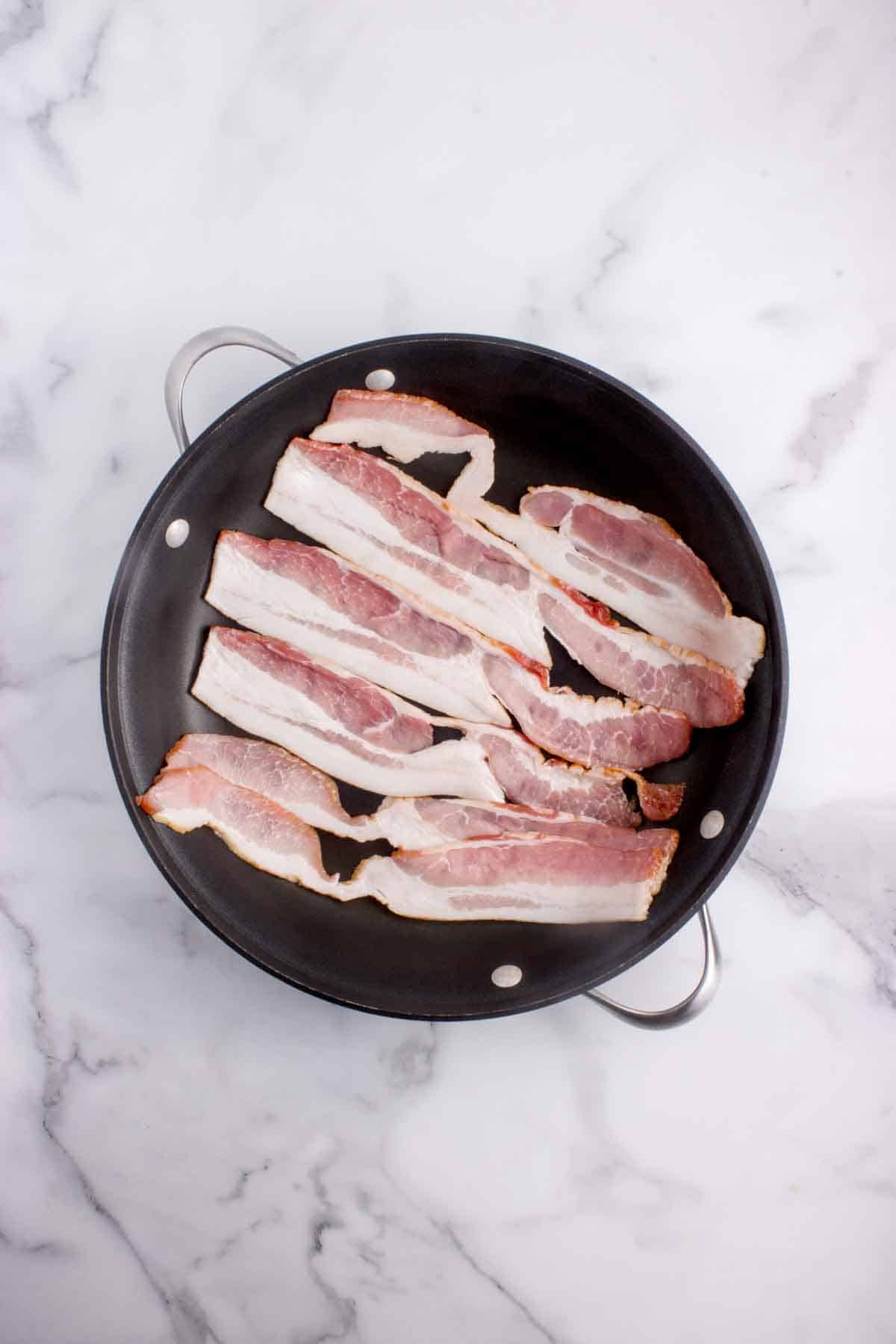 Slices of bacon in a pan.