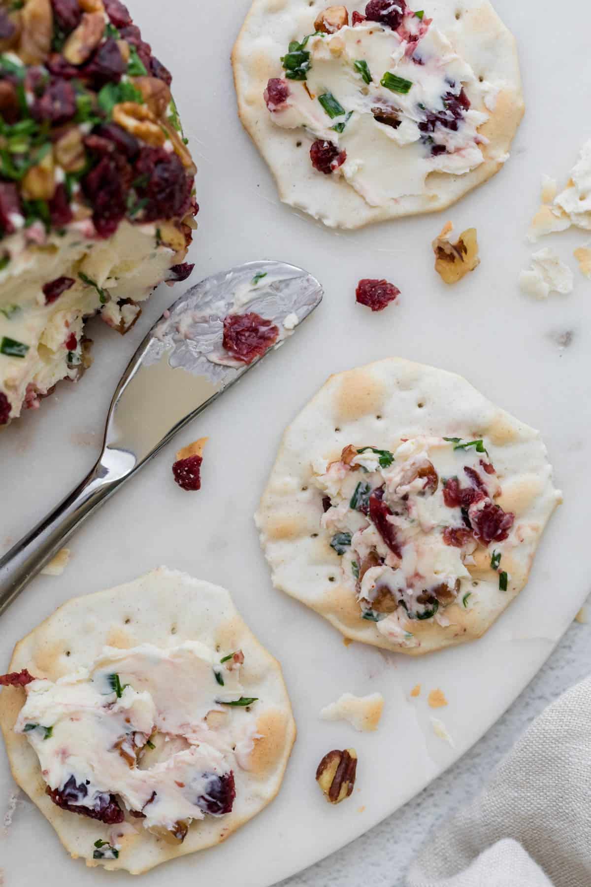 A cheeseball spread onto crackers.