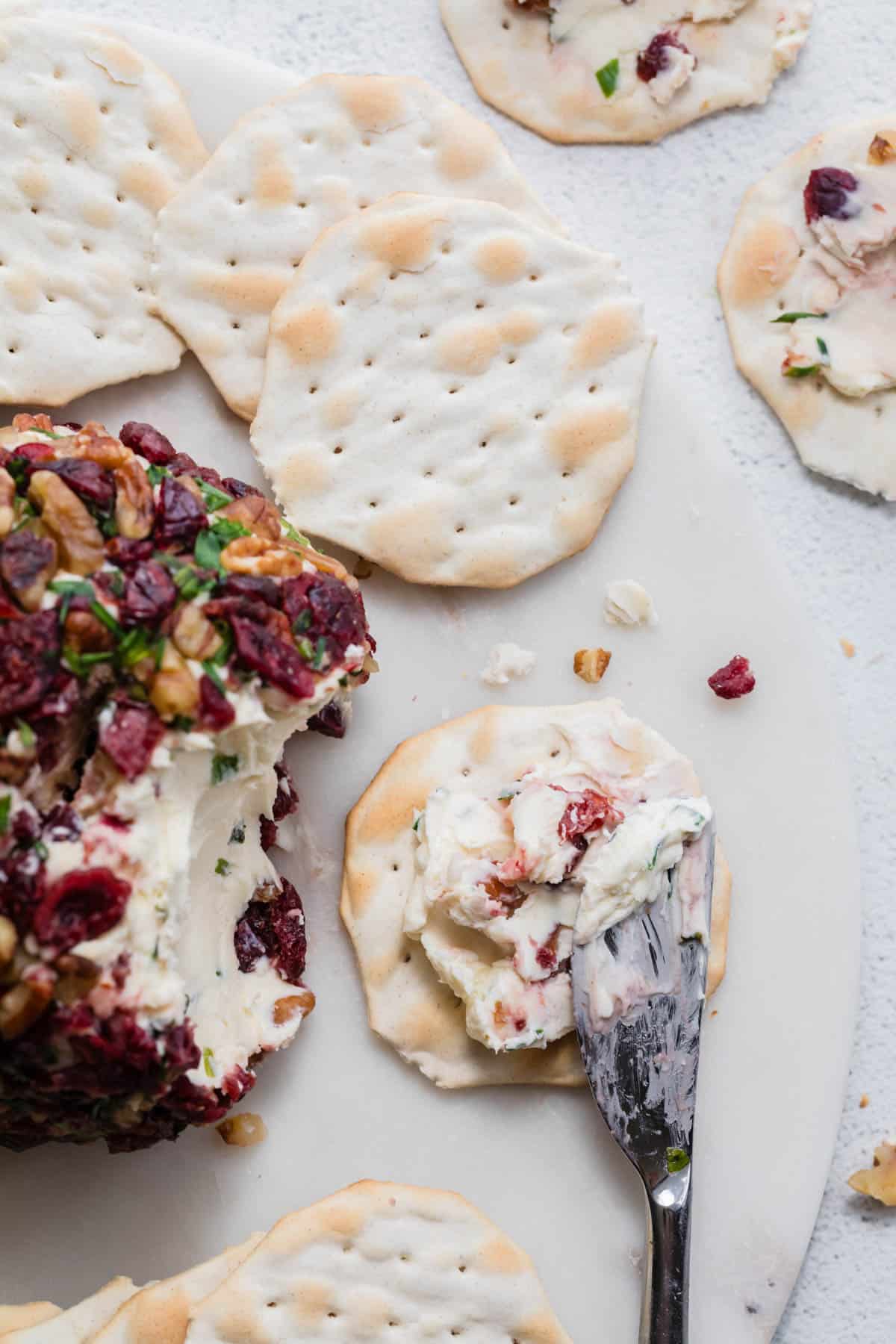 A cracker with cheeseball spread on it.