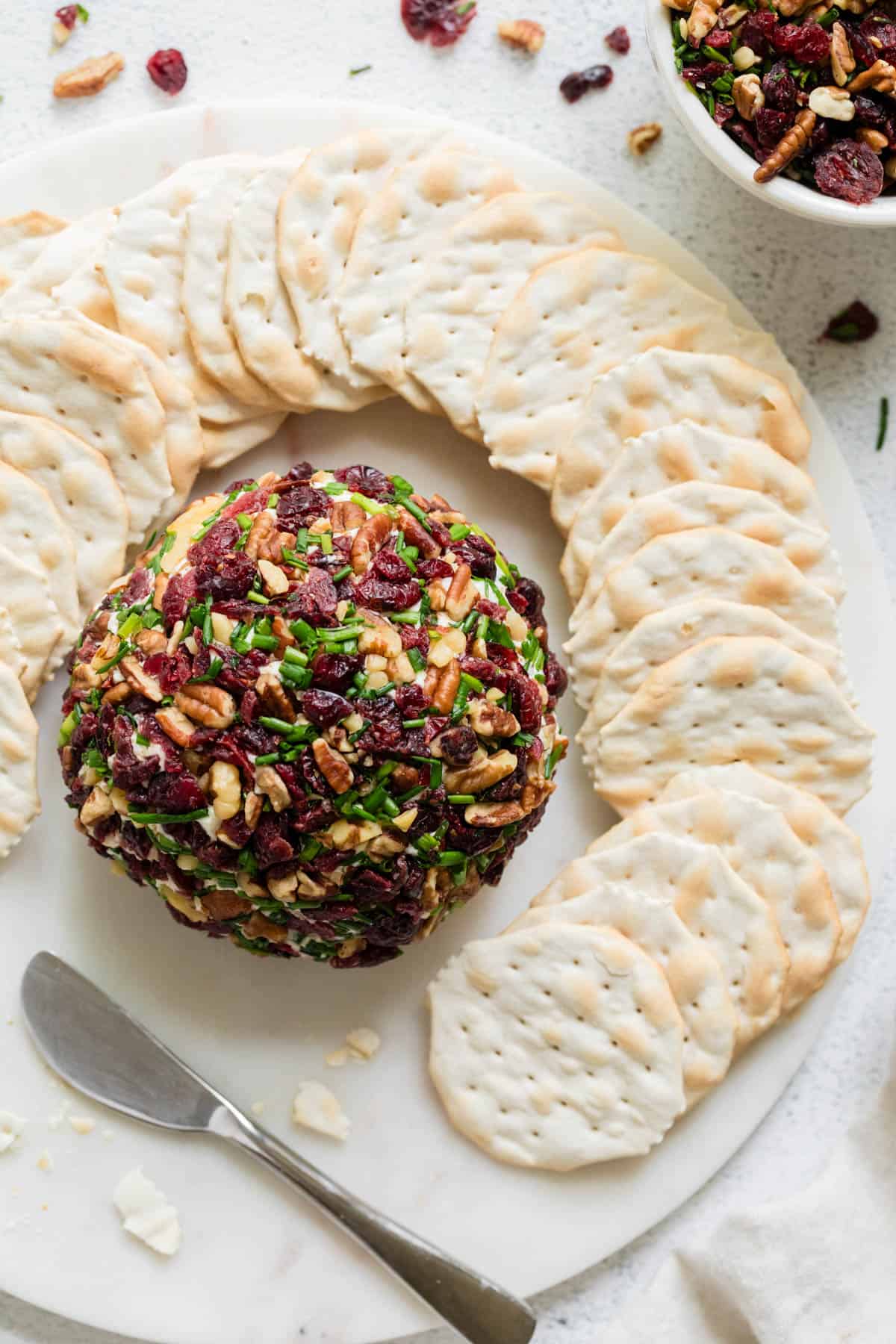 A cheeseball surrounded by crackers.