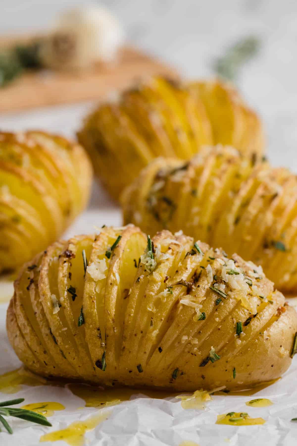 Roasted hasselback potatoes sprinkled with parmesan and rosemary.