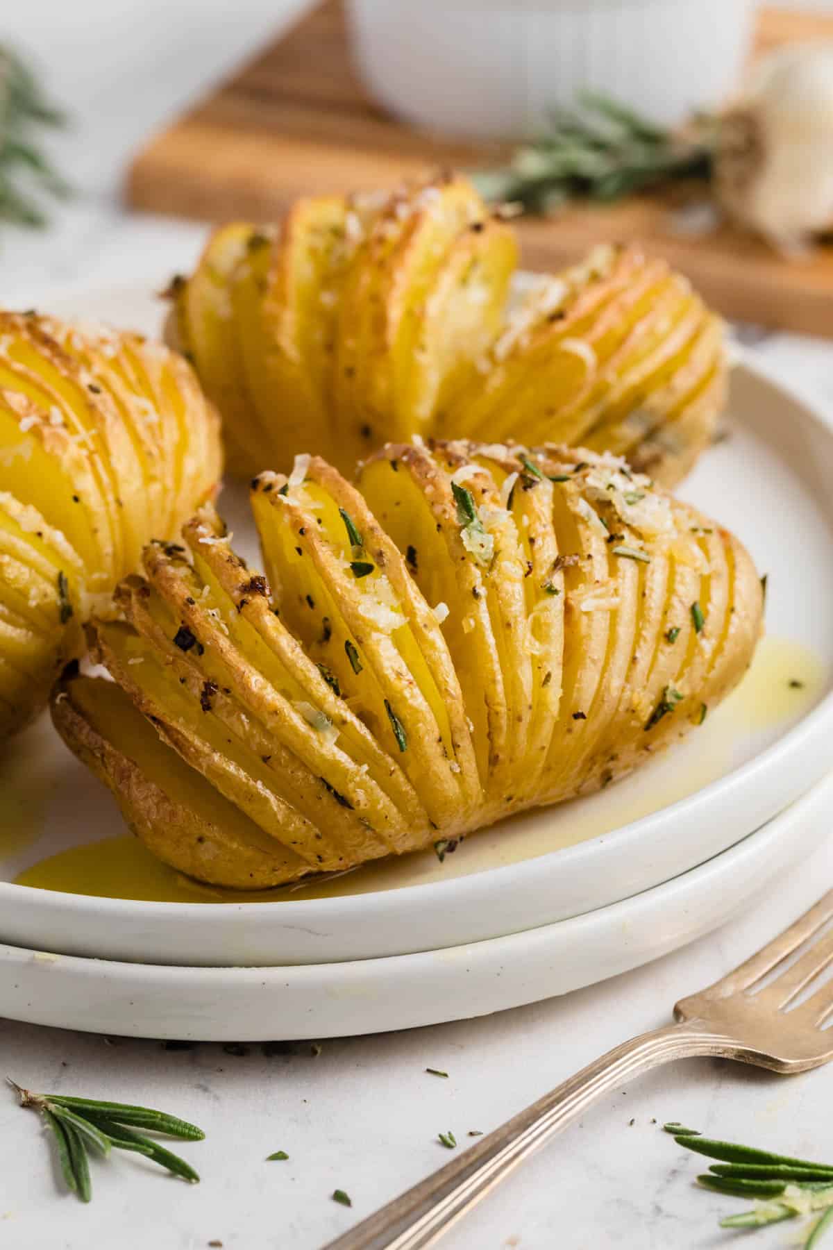 Hasselback potatoes on a white plate.