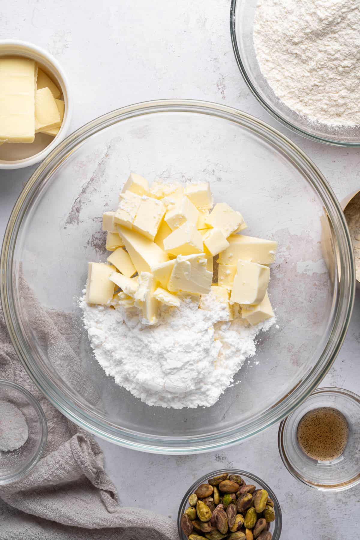 Overhead view of diced butter and powdered sugar in a large bowl.