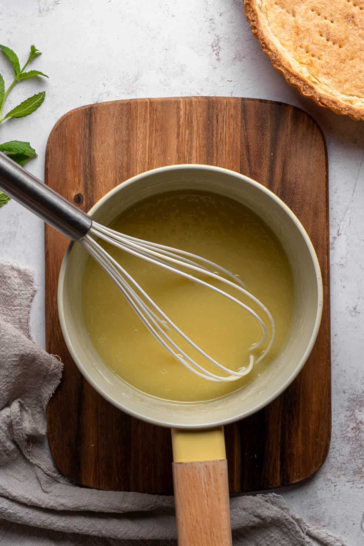 White chocolate ganache filling in a pan with a whisk.