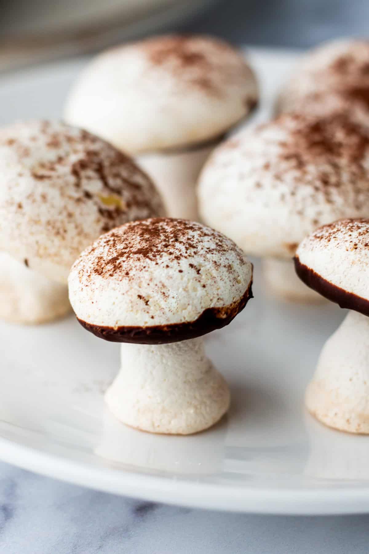 Finished meringue mushrooms on a plate.