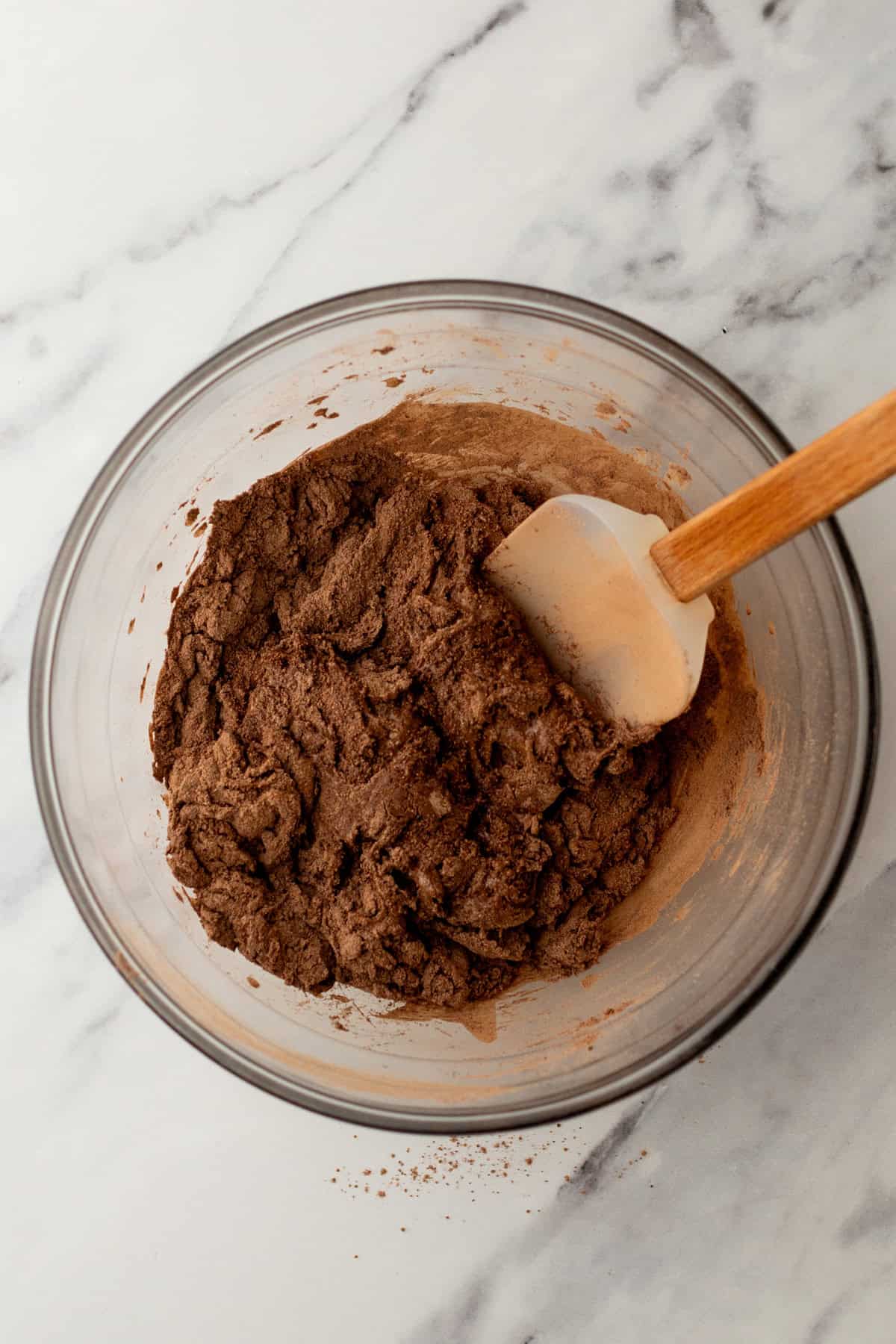 Combining wet and dry ingredients in a glass mixing bowl.