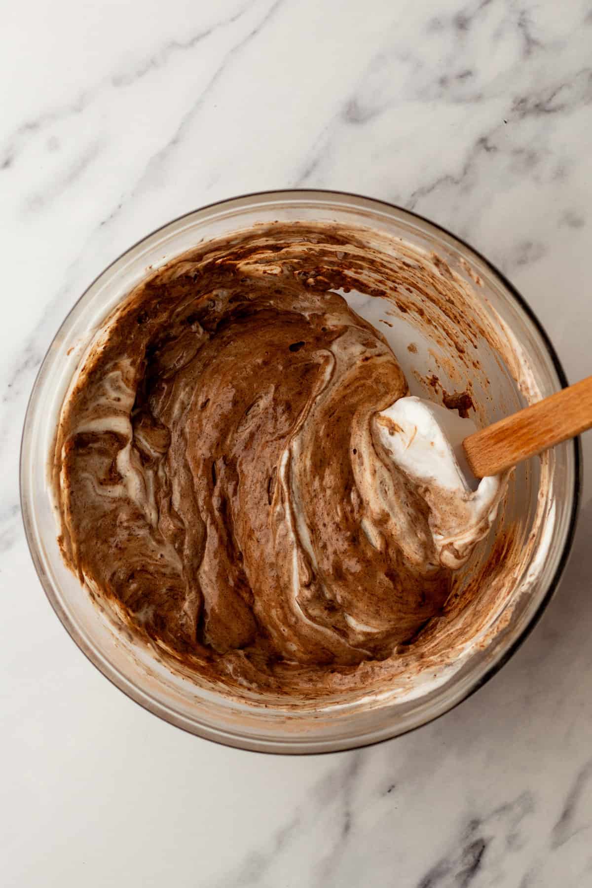 Folding egg whites into chocolate cake batter.