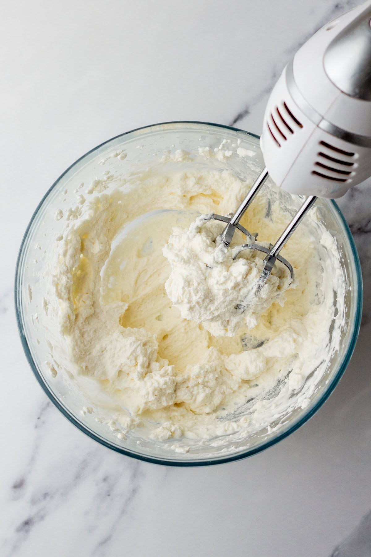 Making sweetened whipped cream in a mixing bowl.