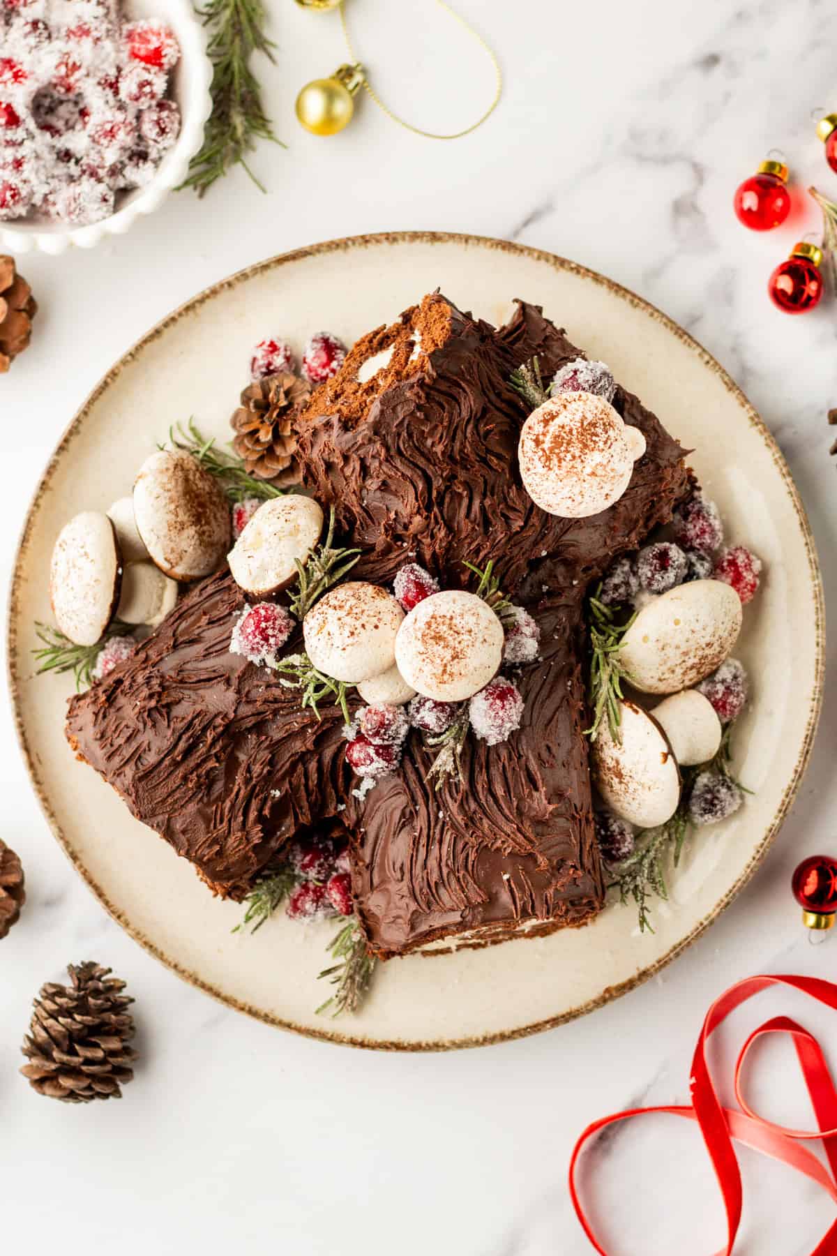 An overhead image of a yule log cake with meringue mushroom decorations.