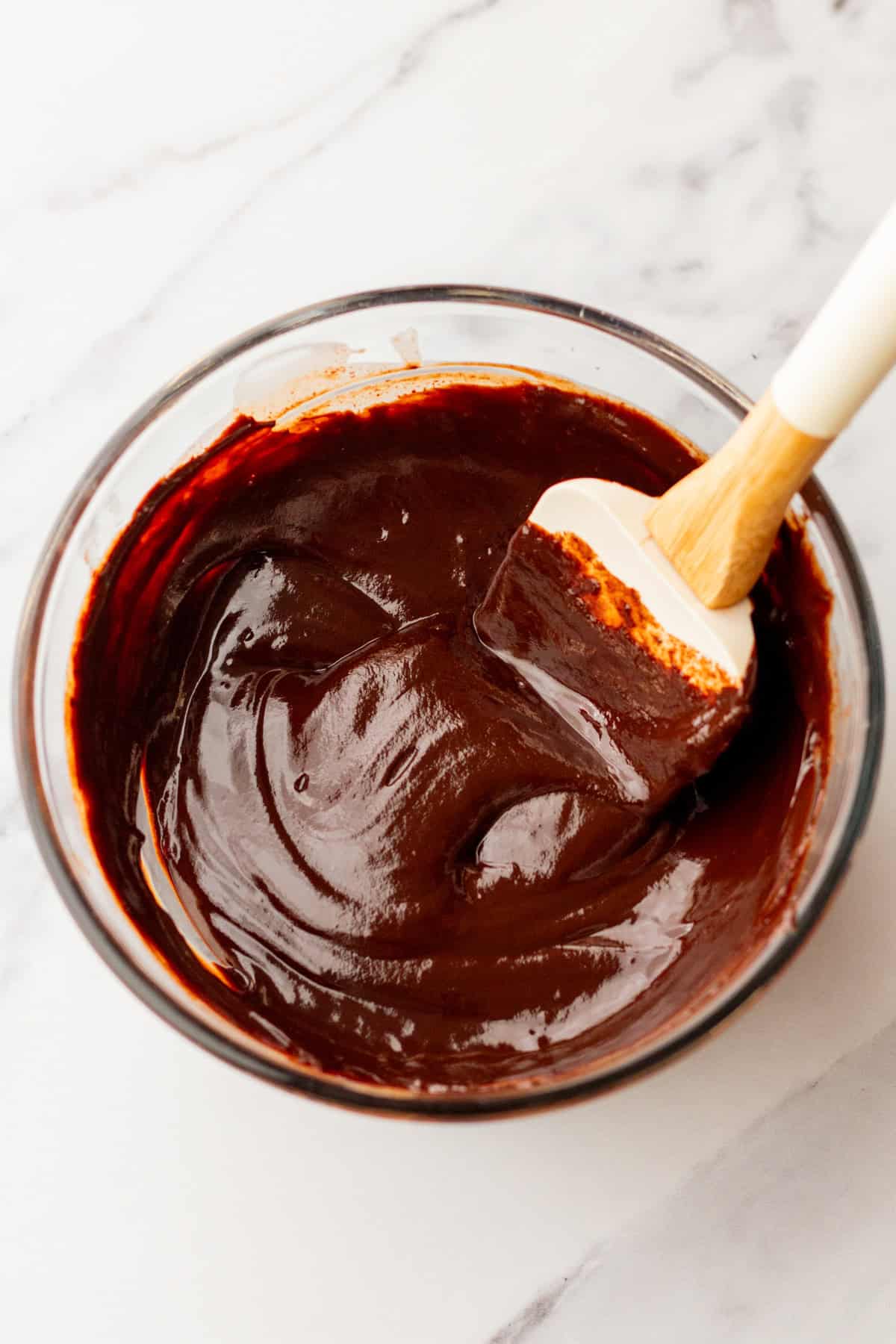 Thick chocolate ganache in a mixing bowl.