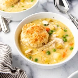 A side image of bowls of chicken pot pie soup in white bowls.