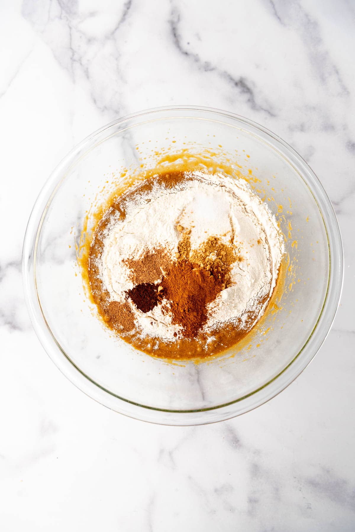 Adding dry ingredients to make a gingerbread dough for bars.