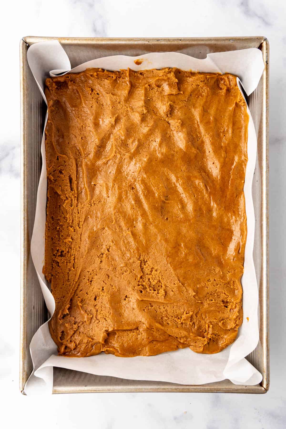 Gingerbread dough pressed into a 9x13-inch baking pan.