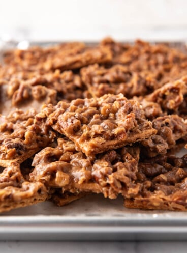 An image of pecan pie bark piled on a baking sheet lined with aluminum foil.