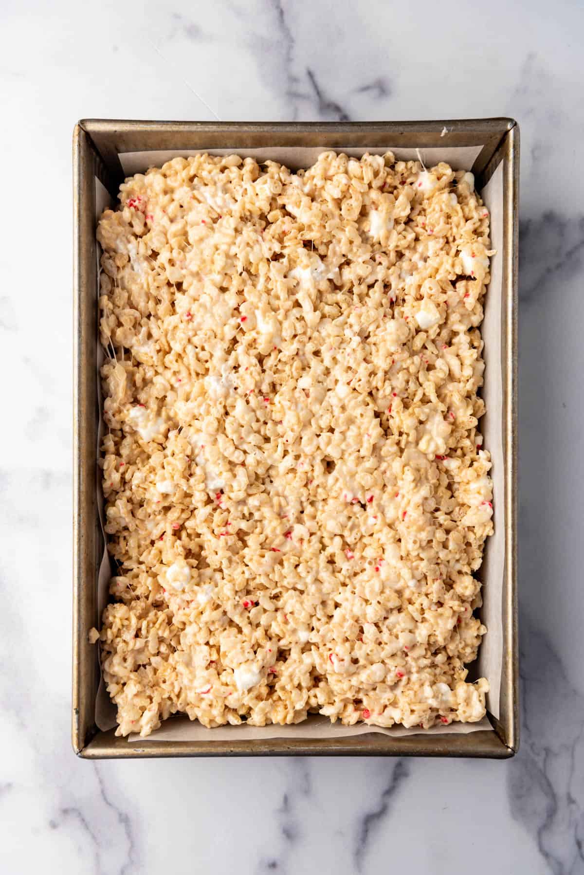 Rice Krispies treats press into a large pan.