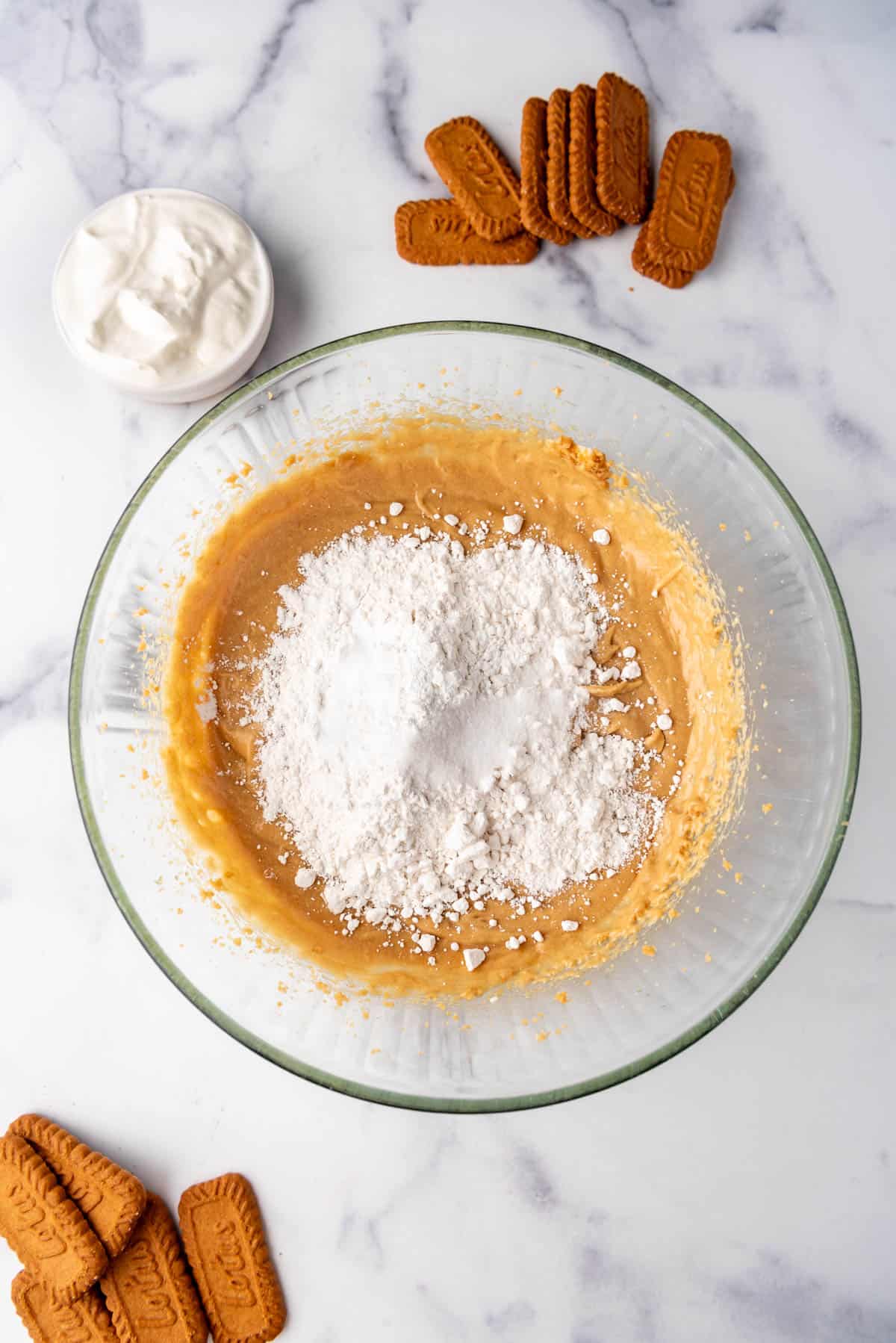 Adding dry ingredients to cake batter in a bowl.