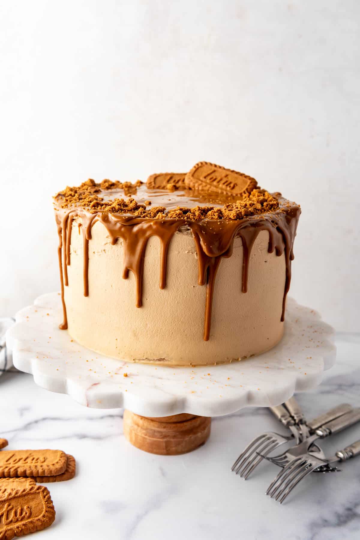 A tall layer cake covered in melted Biscoff cookie butter drip.