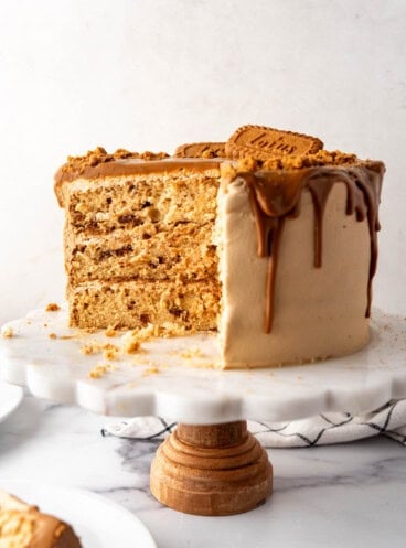 A Biscoff cookie butter cake on a white cake stand.