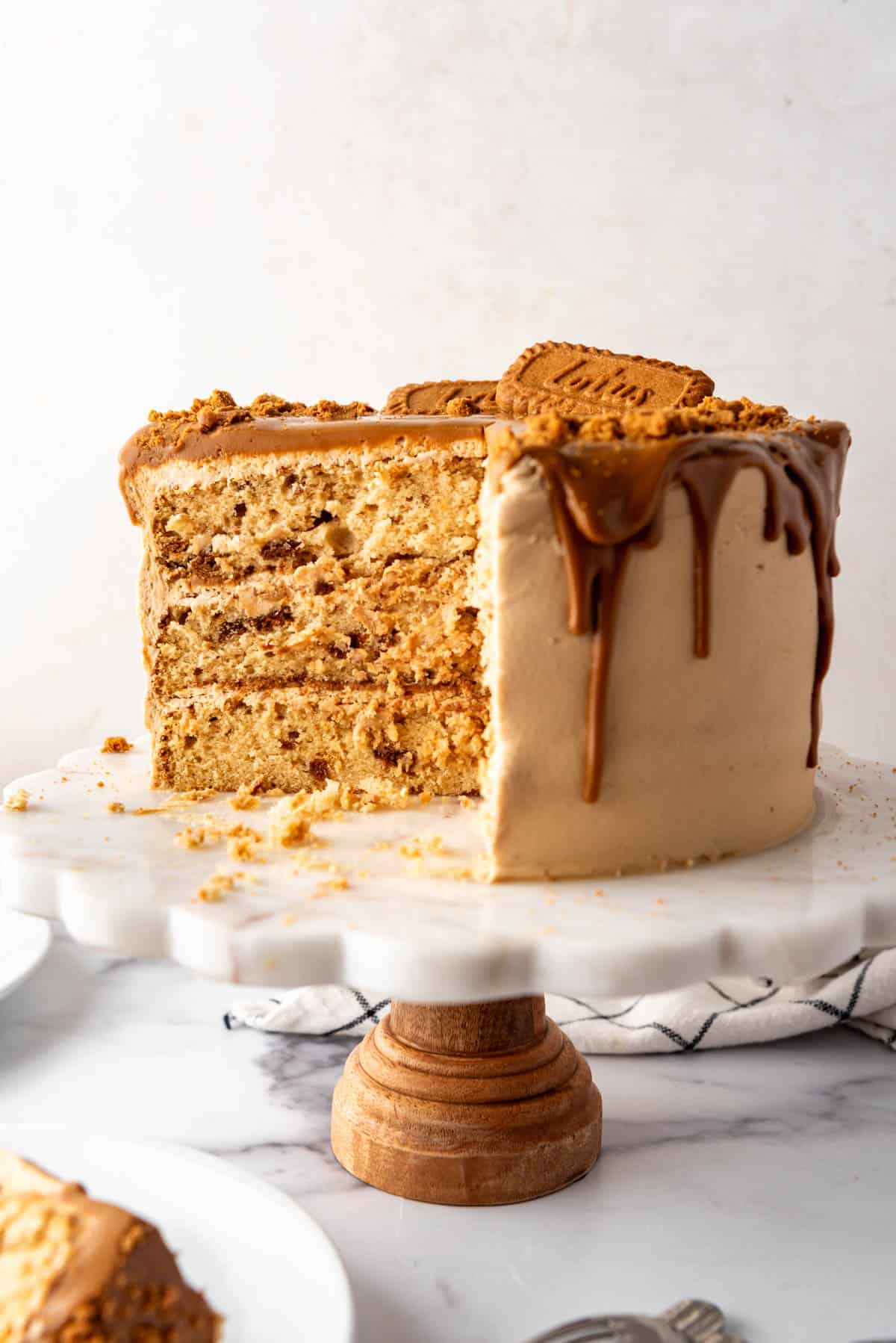 A Biscoff cookie butter cake on a white cake stand.